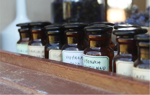 A collection of small, dark apothecary bottles used for creating perfumes.