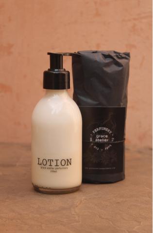 A bottle of Grace Atelier lotion next to its packaging.