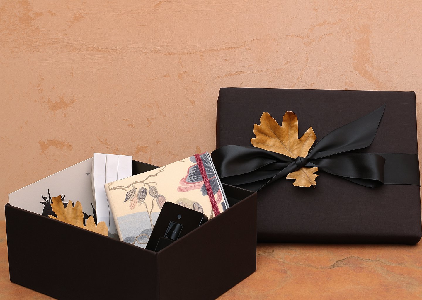 The Grace Atelier Discovery Box, elegantly wrapped with a black silk ribbon and a golden leaf.